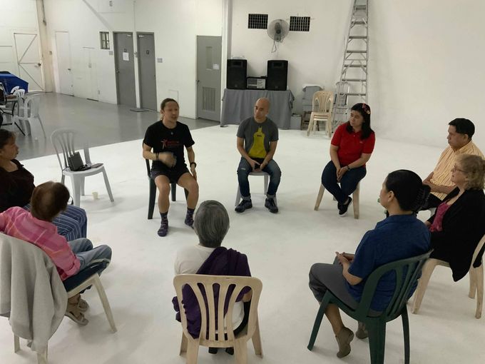 Novy Bereber leading a seated circle of older participants in a Dance for Parkinson’s class