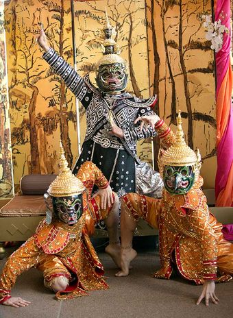Three masked dancers in gilded costume in Opera Australia’s production of The King and I